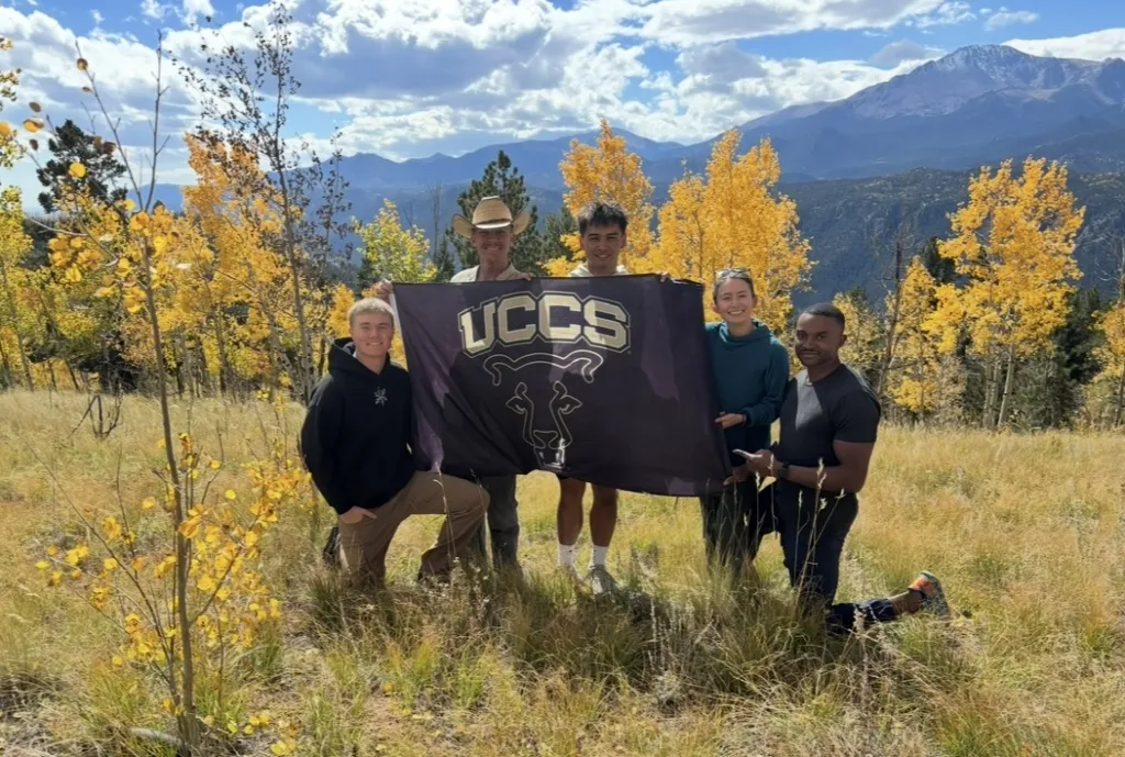 Air Force ROTC Cadets holding the UCCS flag on a trail in Colorado Springs
